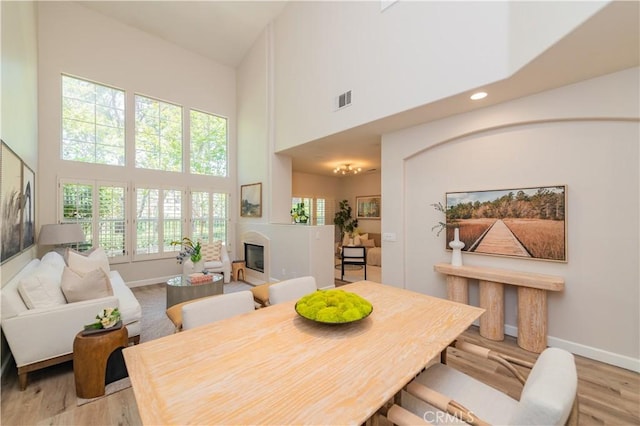 5 Bretagne, Newport Coast, CA 92657 - dining area featuring a high ceiling, a glass covered fireplace, plenty of natural light, light wood finished floors, and recessed lighting