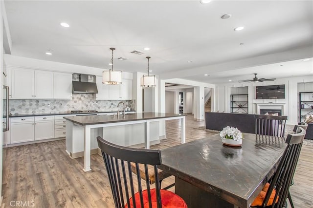 13438 Ambrosia Ct, Riverside, CA 92503 - dining room with light wood finished floors, a lit fireplace, recessed lighting, and ceiling fan
