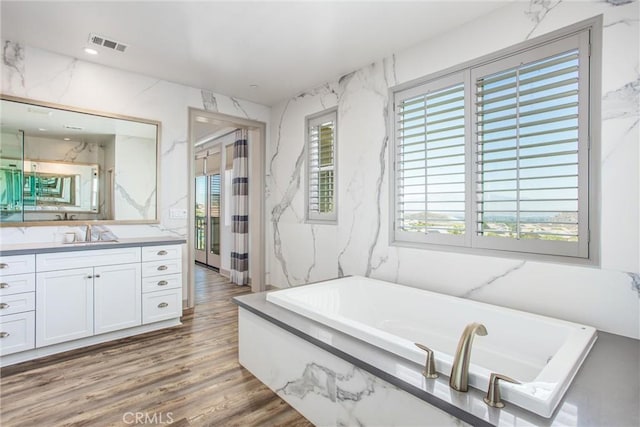 13438 Ambrosia Ct, Riverside, CA 92503 - full bath with vanity, a garden tub, and wood finished floors