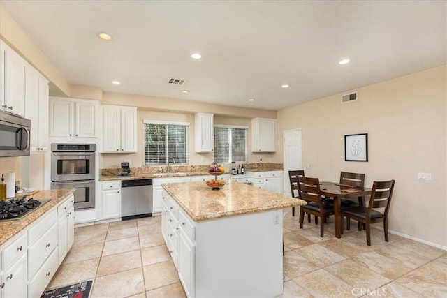 31578 Waterfall Way, Murrieta, CA 92563 - kitchen with stainless steel appliances, a kitchen island, white cabinets, light stone counters, and recessed lighting