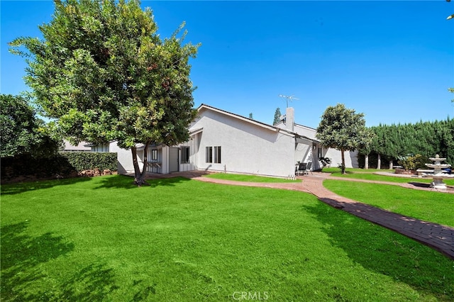 1061 Regis Way, Tustin, CA 92780 - rear view of property featuring a yard, stucco siding, and a chimney