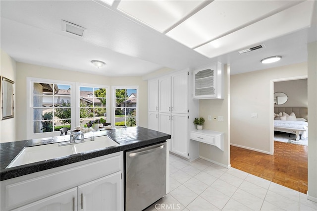 1061 Regis Way, Tustin, CA 92780 - kitchen with stainless steel dishwasher, dark countertops, and white cabinetry