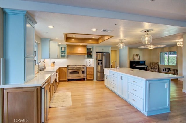 43350 Dunlap, Banning, CA 92220 - kitchen with appliances with stainless steel finishes, light countertops, a raised ceiling, light wood finished floors, and glass insert cabinets
