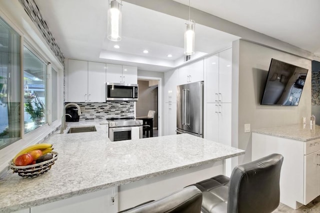 12395 Filera Rd, San Diego, CA 92128 - kitchen featuring stainless steel appliances, a peninsula, a tray ceiling, recessed lighting, and backsplash