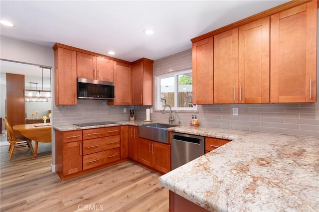4368 Manchester Ct, Santa Maria, CA 93455 - kitchen featuring appliances with stainless steel finishes, light wood-type flooring, brown cabinetry, light stone countertops, and recessed lighting