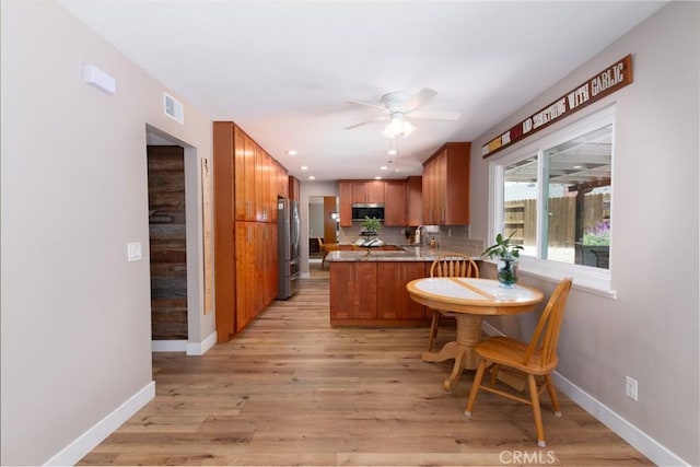 4368 Manchester Ct, Santa Maria, CA 93455 - kitchen featuring stainless steel appliances, a peninsula, ceiling fan, brown cabinetry, and light wood finished floors