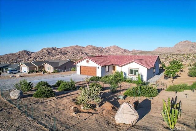 7765 Elwood St, Joshua Tree, CA 92252 - view of front of property featuring driveway, a garage, a mountain view, and a tile roof