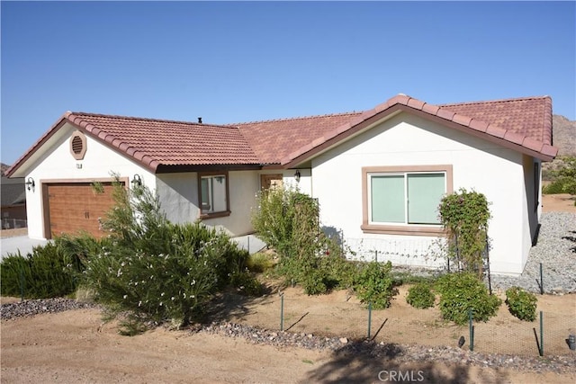 7765 Elwood St, Joshua Tree, CA 92252 - ranch-style house featuring a garage, a tiled roof, and stucco siding