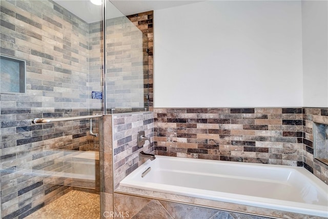 7765 Elwood St, Joshua Tree, CA 92252 - bathroom featuring a bath, a stall shower, and tile walls
