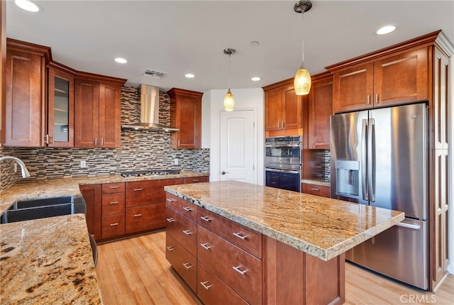7765 Elwood St, Joshua Tree, CA 92252 - kitchen featuring appliances with stainless steel finishes, wall chimney range hood, light wood-style floors, a kitchen island, and recessed lighting