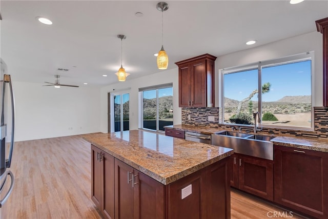 7765 Elwood St, Joshua Tree, CA 92252 - kitchen featuring backsplash, light wood-style floors, light stone counters, hanging light fixtures, and ceiling fan