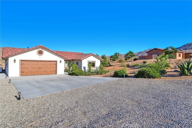 7765 Elwood St, Joshua Tree, CA 92252 - view of front facade with stucco siding, an attached garage, concrete driveway, and a tiled roof