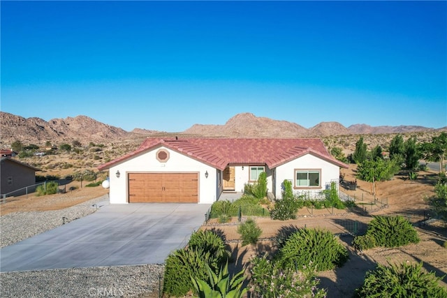 7765 Elwood St, Joshua Tree, CA 92252 - ranch-style home featuring an attached garage, driveway, a mountain view, and a tile roof
