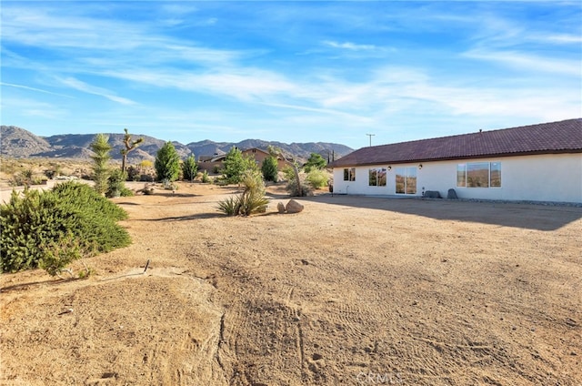7765 Elwood St, Joshua Tree, CA 92252 - back of house featuring a mountain view and stucco siding