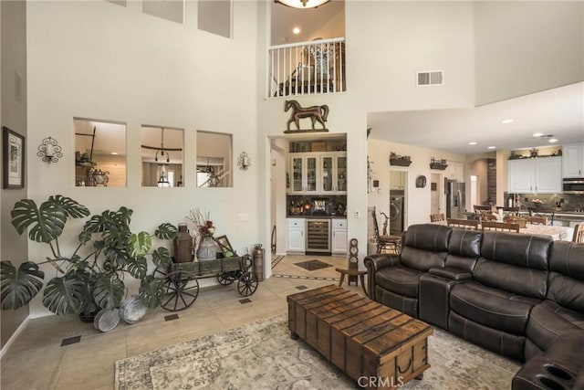 22760 Shadygrove Ct, Wildomar, CA 92595 - living room featuring beverage cooler, a towering ceiling, light tile patterned floors, washer / dryer, and recessed lighting