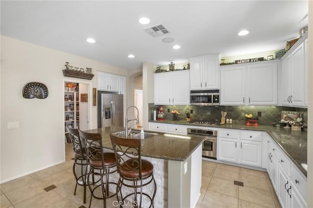 22760 Shadygrove Ct, Wildomar, CA 92595 - kitchen featuring appliances with stainless steel finishes, arched walkways, decorative backsplash, light tile patterned flooring, and recessed lighting