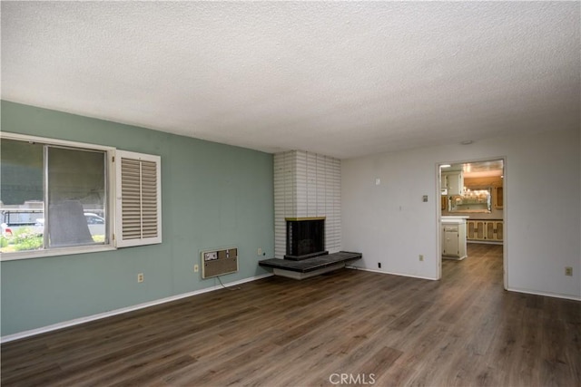 1032 S Golden W Ave Unit A, Arcadia, CA 91007 - unfurnished living room featuring a textured ceiling, wood finished floors, a brick fireplace, and a wall unit AC