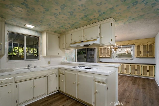 1032 S Golden W Ave Unit A, Arcadia, CA 91007 - kitchen with tile counters, a peninsula, dark wood-style flooring, under cabinet range hood, and a chandelier