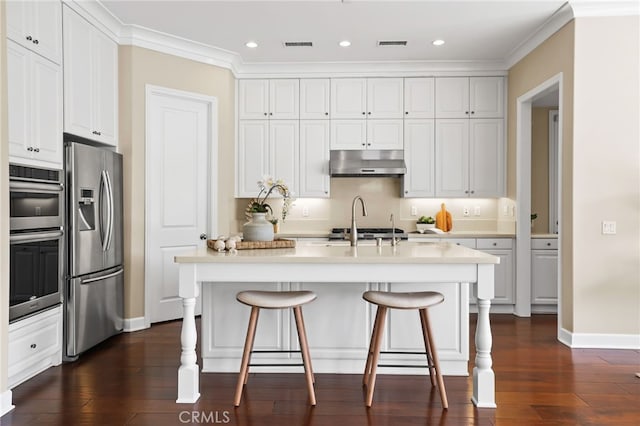 54 Sycamore Bnd, Irvine, CA 92620 - kitchen with appliances with stainless steel finishes, under cabinet range hood, dark wood-style flooring, white cabinets, and light countertops