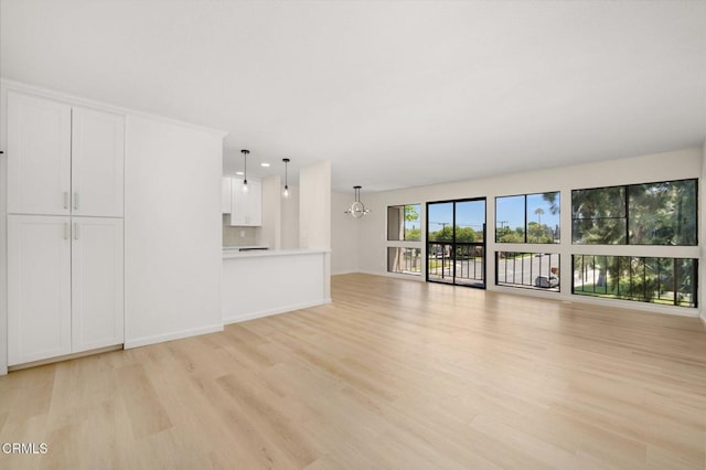 5300 E Atherton St Unit 2F, Long Beach, CA 90815 - unfurnished living room featuring light wood-style floors and a chandelier