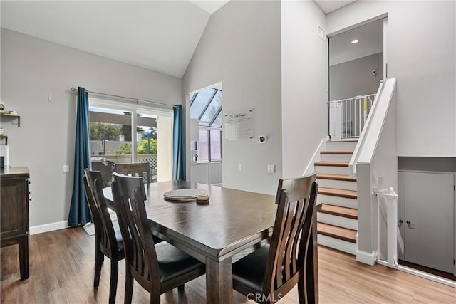 222 N Singingwood St Unit 9, Orange, CA 92869 - dining space featuring light wood-style floors, high vaulted ceiling, and stairs