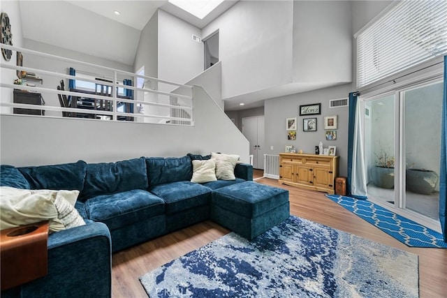 222 N Singingwood St Unit 9, Orange, CA 92869 - living room featuring a towering ceiling, stairs, wood finished floors, and a skylight