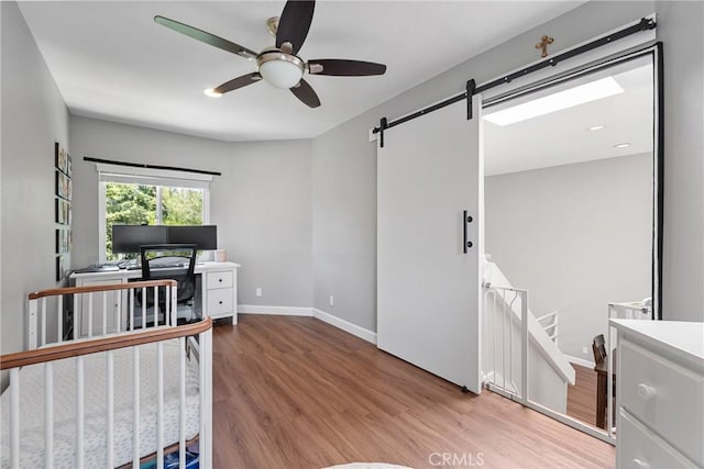 222 N Singingwood St Unit 9, Orange, CA 92869 - bedroom with wood finished floors, a barn door, and ceiling fan