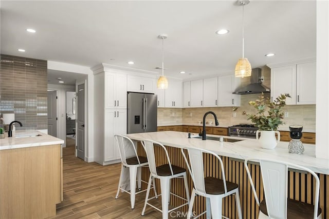 235 Via Ballena, San Clemente, CA 92672 - kitchen featuring wall chimney exhaust hood, appliances with stainless steel finishes, light stone countertops, a kitchen breakfast bar, and backsplash