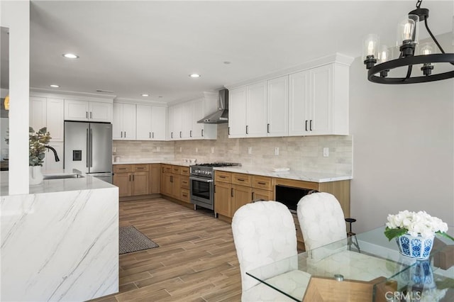 235 Via Ballena, San Clemente, CA 92672 - kitchen with stainless steel appliances, wall chimney range hood, a chandelier, light wood finished floors, and light stone countertops