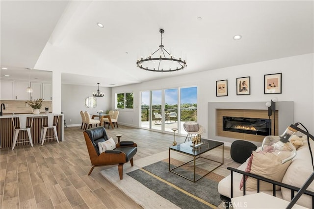 235 Via Ballena, San Clemente, CA 92672 - living area with a chandelier, recessed lighting, a glass covered fireplace, and light wood-type flooring