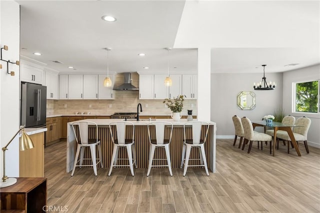 235 Via Ballena, San Clemente, CA 92672 - kitchen featuring wall chimney range hood, light countertops, light wood-type flooring, backsplash, and recessed lighting