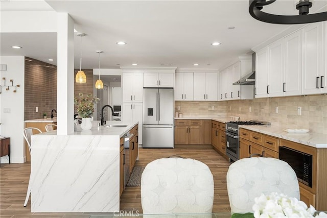 235 Via Ballena, San Clemente, CA 92672 - kitchen with appliances with stainless steel finishes, light wood-type flooring, wall chimney range hood, tasteful backsplash, and light stone countertops