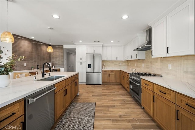 235 Via Ballena, San Clemente, CA 92672 - kitchen with stainless steel appliances, wall chimney exhaust hood, decorative backsplash, pendant lighting, and light wood-style flooring