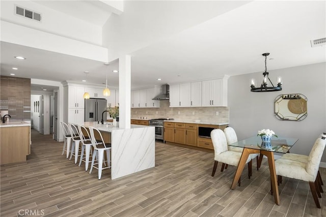 235 Via Ballena, San Clemente, CA 92672 - kitchen featuring appliances with stainless steel finishes, wall chimney range hood, light wood-style flooring, backsplash, and recessed lighting