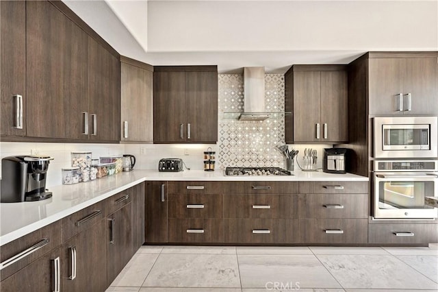 56720 Jack Nicklaus Blvd, La Quinta, CA 92253 - kitchen with stainless steel appliances, wall chimney exhaust hood, light countertops, and dark brown cabinetry