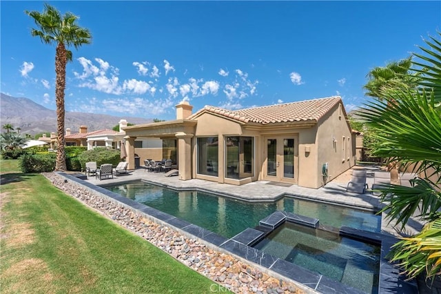 56720 Jack Nicklaus Blvd, La Quinta, CA 92253 - rear view of house with stucco siding, a chimney, a mountain view, and french doors