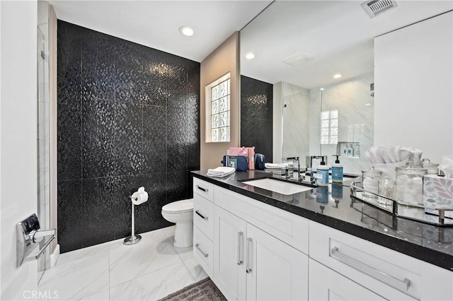 56720 Jack Nicklaus Blvd, La Quinta, CA 92253 - bathroom featuring tile walls, marble look tile flooring, vanity, a tile shower, and recessed lighting