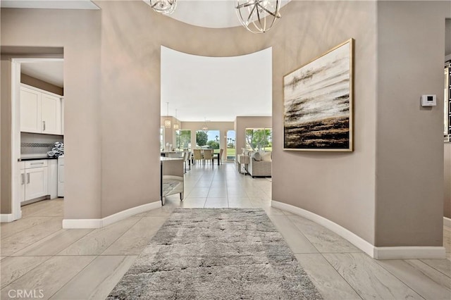 56720 Jack Nicklaus Blvd, La Quinta, CA 92253 - hallway with a chandelier, a towering ceiling, and light marble finish flooring