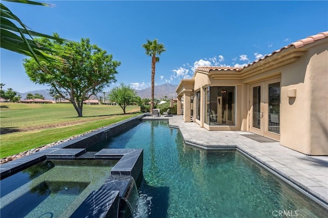 56720 Jack Nicklaus Blvd, La Quinta, CA 92253 - view of swimming pool featuring a mountain view, a patio area, a yard, french doors, and a pool with connected hot tub