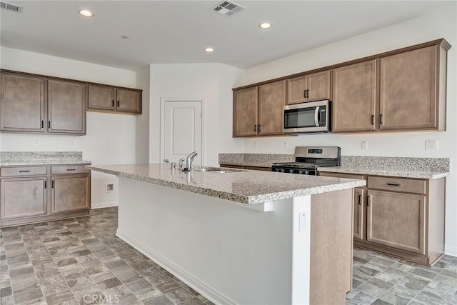 29601 Tulipwood St, Menifee, CA 92584 - kitchen with stainless steel appliances, an island with sink, recessed lighting, and light stone counters