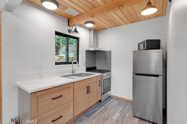 33198 Arrowbear Dr, Running Springs, CA 92382 - kitchen with appliances with stainless steel finishes, wall chimney range hood, light brown cabinetry, light wood-style floors, and a wood ceiling with exposed beams