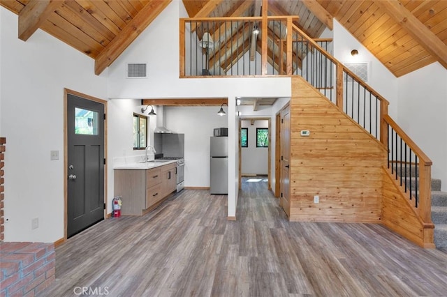 33198 Arrowbear Dr, Running Springs, CA 92382 - unfurnished living room featuring wood finished floors, high vaulted ceiling, stairway, and a wood ceiling with exposed beams