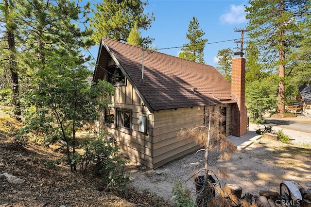 33198 Arrowbear Dr, Running Springs, CA 92382 - view of side of property featuring a shingled roof, a chimney, and a barn