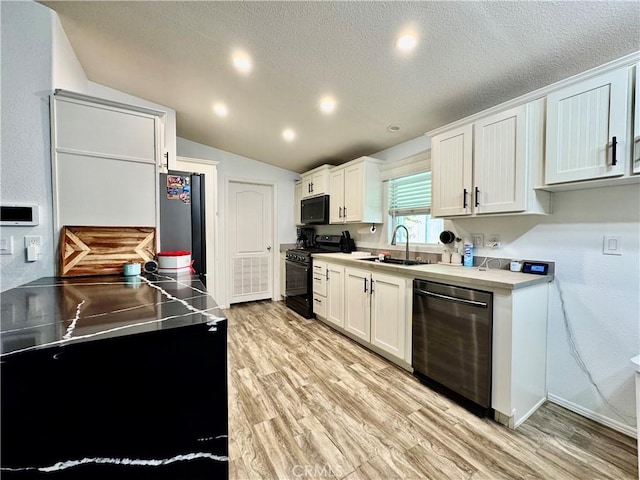 2851 S La Cadena Dr Unit 125, Colton, CA 92324 - kitchen featuring black appliances, light wood-type flooring, a textured ceiling, white cabinets, and vaulted ceiling