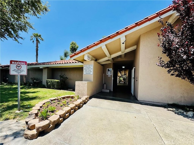 2851 S La Cadena Dr Unit 125, Colton, CA 92324 - doorway to property featuring stucco siding and a lawn
