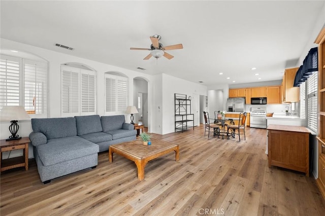 28253 Harmony Ln, Menifee, CA 92584 - living room with a ceiling fan, light wood finished floors, arched walkways, and recessed lighting