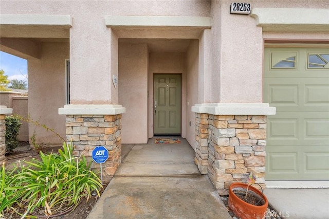 28253 Harmony Ln, Menifee, CA 92584 - property entrance with stone siding, a garage, and stucco siding
