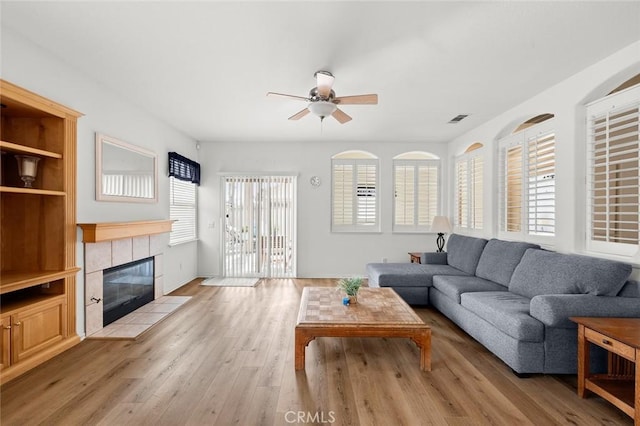 28253 Harmony Ln, Menifee, CA 92584 - living room featuring ceiling fan, light wood finished floors, and a tile fireplace