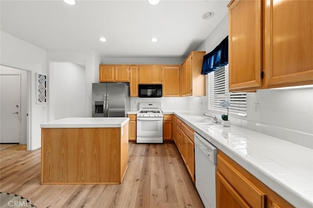28253 Harmony Ln, Menifee, CA 92584 - kitchen with white appliances, tile counters, light wood-style flooring, a center island, and recessed lighting