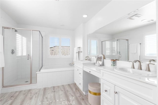 4062 Tamarind Rdg, Lake Elsinore, CA 92530 - bathroom with double vanity, a shower stall, a bath, wood finished floors, and recessed lighting